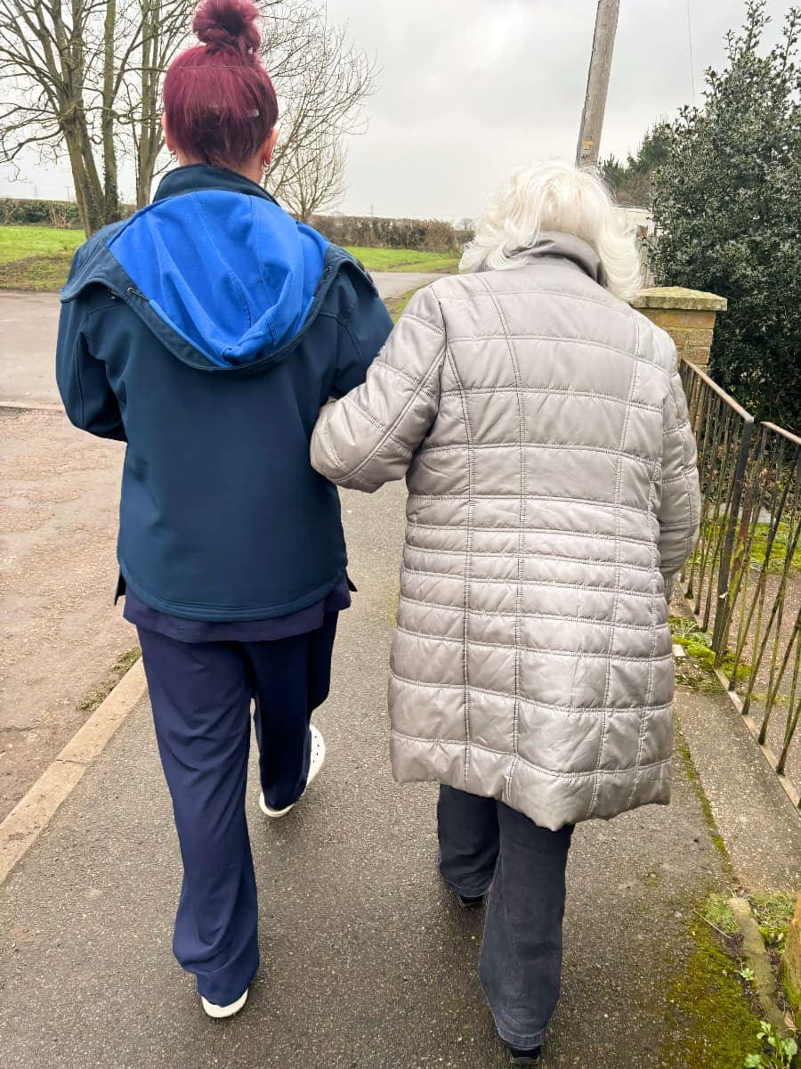 Carer supporting a client on an outside walk