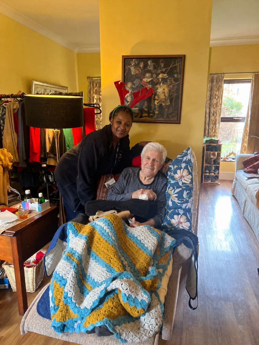Carer supporting a client with breakfast at home