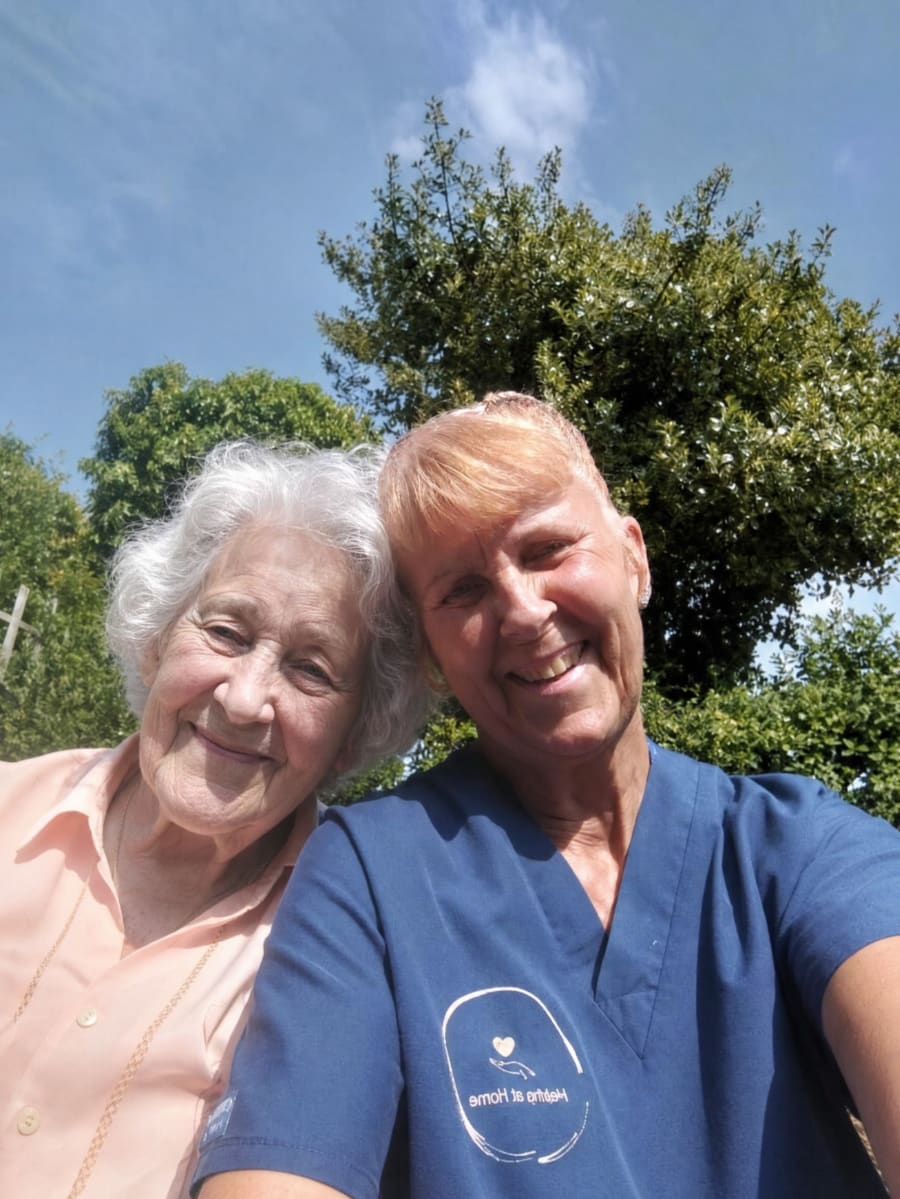 Carer laughing with a client in their garden
